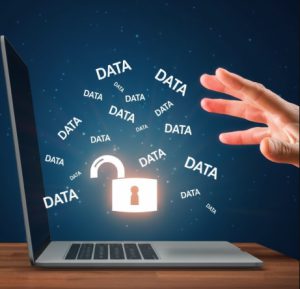 Ein Laptop mit einem leuchtenden, geöffneten Vorhängeschloss auf dem Display, aus dem zahlreiche „DATA“-Schriftzüge in Richtung einer zugreifenden Hand schweben.